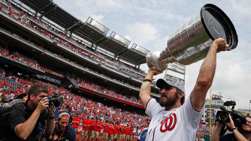 Washington Capitals' Alex Ovechkin, from Russia, lifts the Stanley Cup on the field before a baseball game between the Washington Nationals and the San Francisco Giants at Nationals Park, Saturday, June 9, 2018, in Washington.