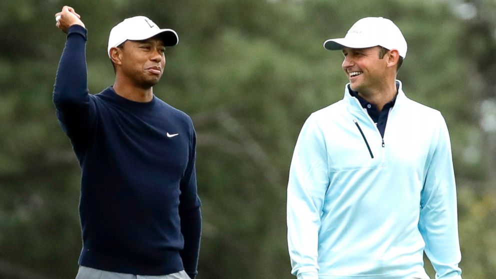 Tiger Woods and Matt Parziale walk up the first fairway during a practice round for the Masters golf tournament, April 4, 2018, in Augusta, Ga.
