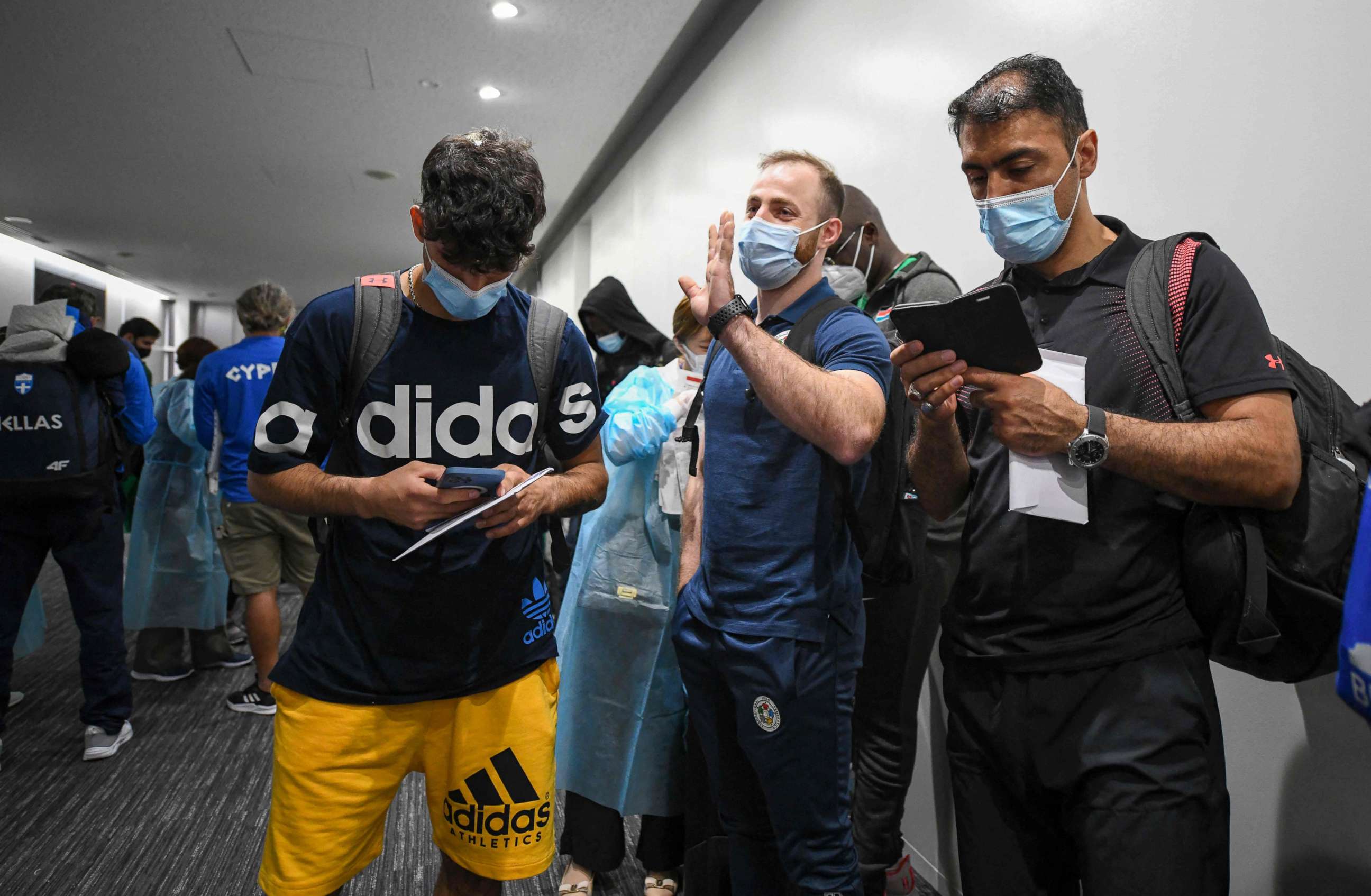 PHOTO: Three members of the Olympic refugee team, Abdullah Sediqi (L), Ahmad Alikaj (C) and coach Alireza Nassrazadany arrive at Narita international airport in Narita, Chiba prefecture on July 14, 2021.