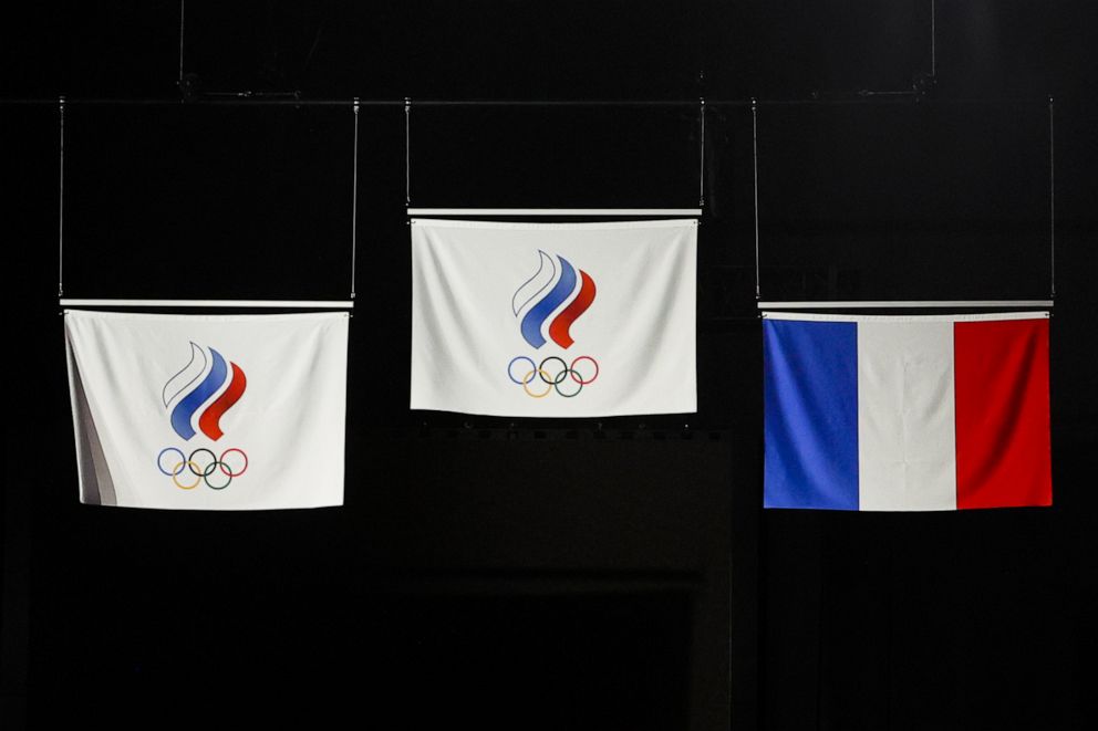 PHOTO: The Russian Olympic Committee and France flags are raised as the national anthem plays during the fencing women's individual sabre medal ceremony, July 26, 2021.
