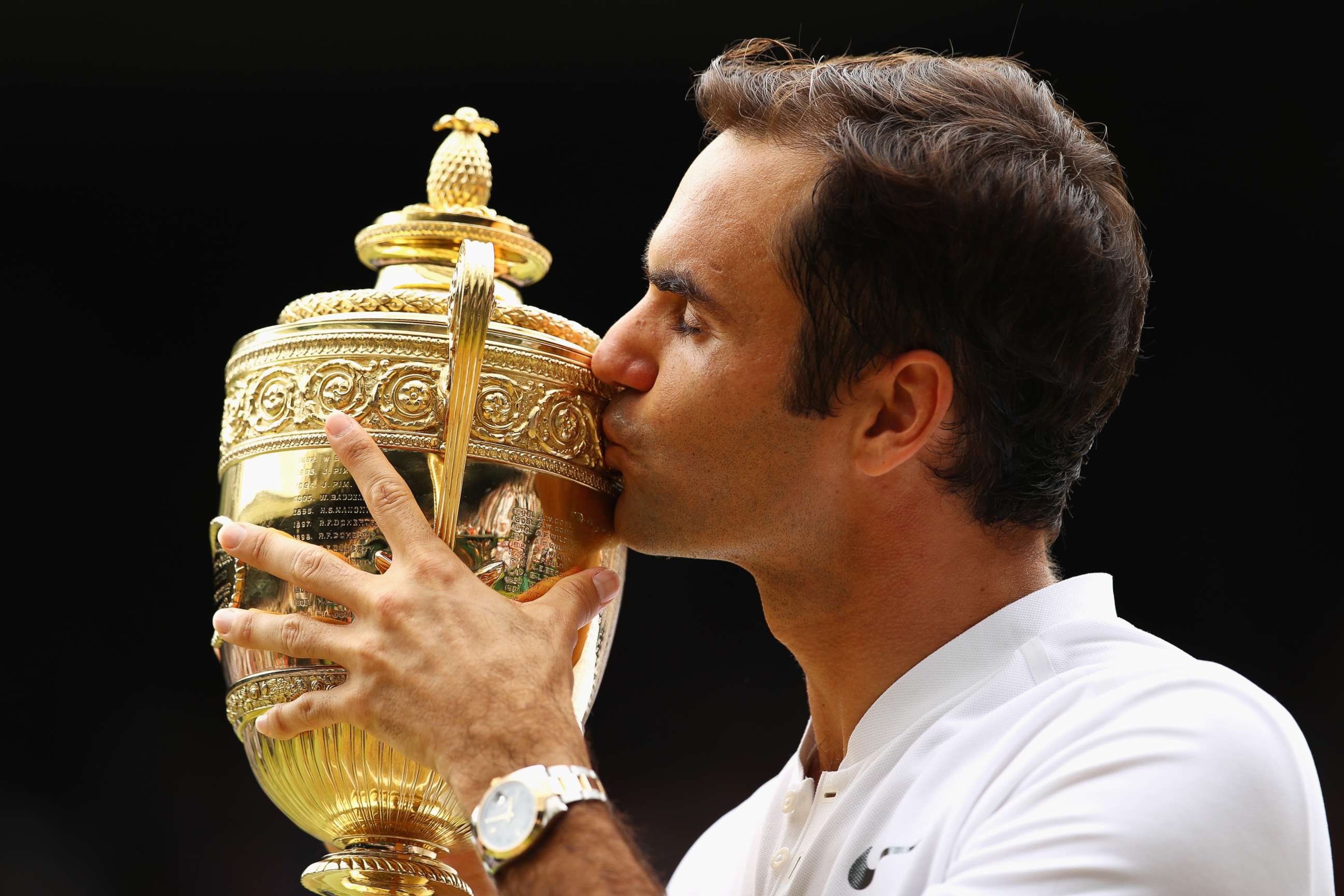 PHOTO: Roger Federer of Switzerland kisses the trophy after winning the Wimbledon men's tennis championship, July 16, 2017, in London.