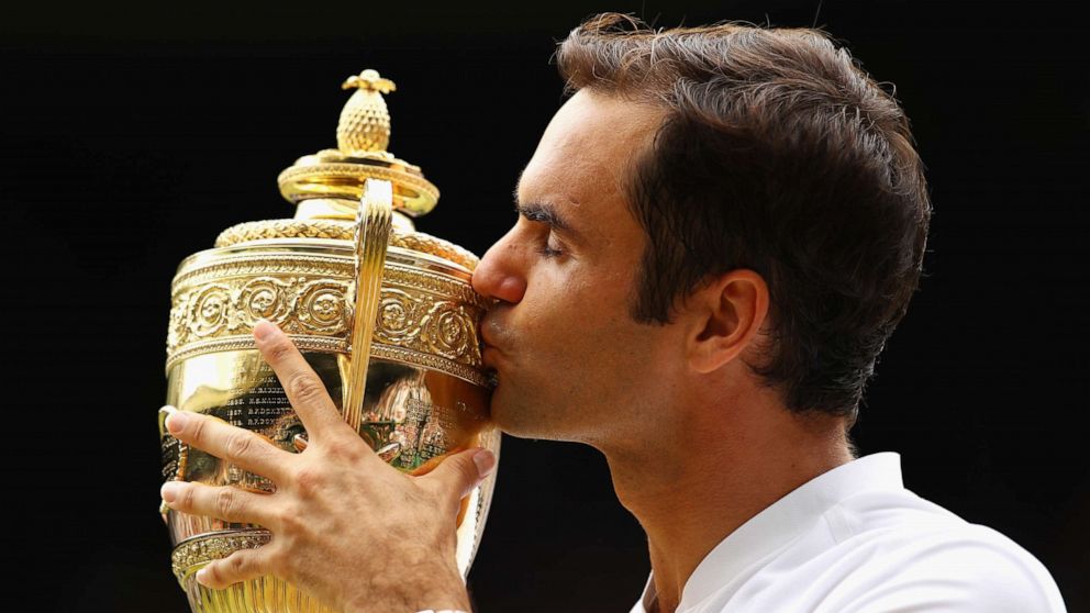 PHOTO: Roger Federer of Switzerland kisses the trophy after winning the Wimbledon men's tennis championship, July 16, 2017, in London.