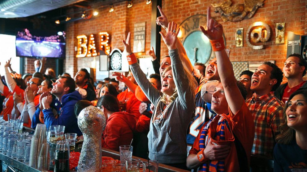 Denver Broncos fans cheer as their team takes the field against the Seattle Seahawks while watching the NFL Super Bowl XLVIII at the View House bar in Denver, Colo. on Feb. 2, 2014.
