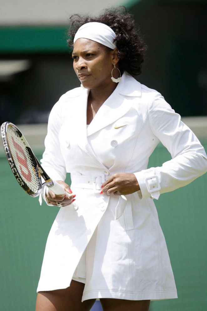 PHOTO: Serena Williams wears a belted raincoat while warming up for her women's singles first round match at Wimbledon,June 23, 2008.