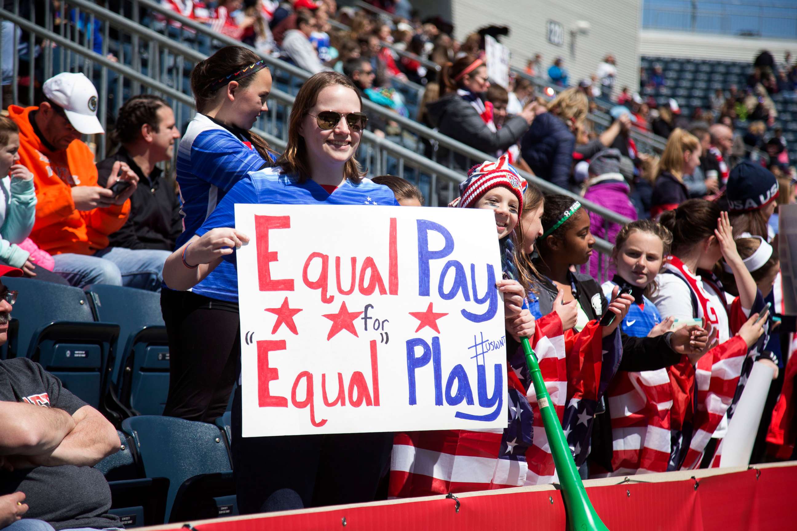PHOTO: A fan of the United States holds a sign that reads, "Equal pay for equal play" during the game against Colombia at Talen Energy Stadium, April 10, 2016, in Chester, Penn.