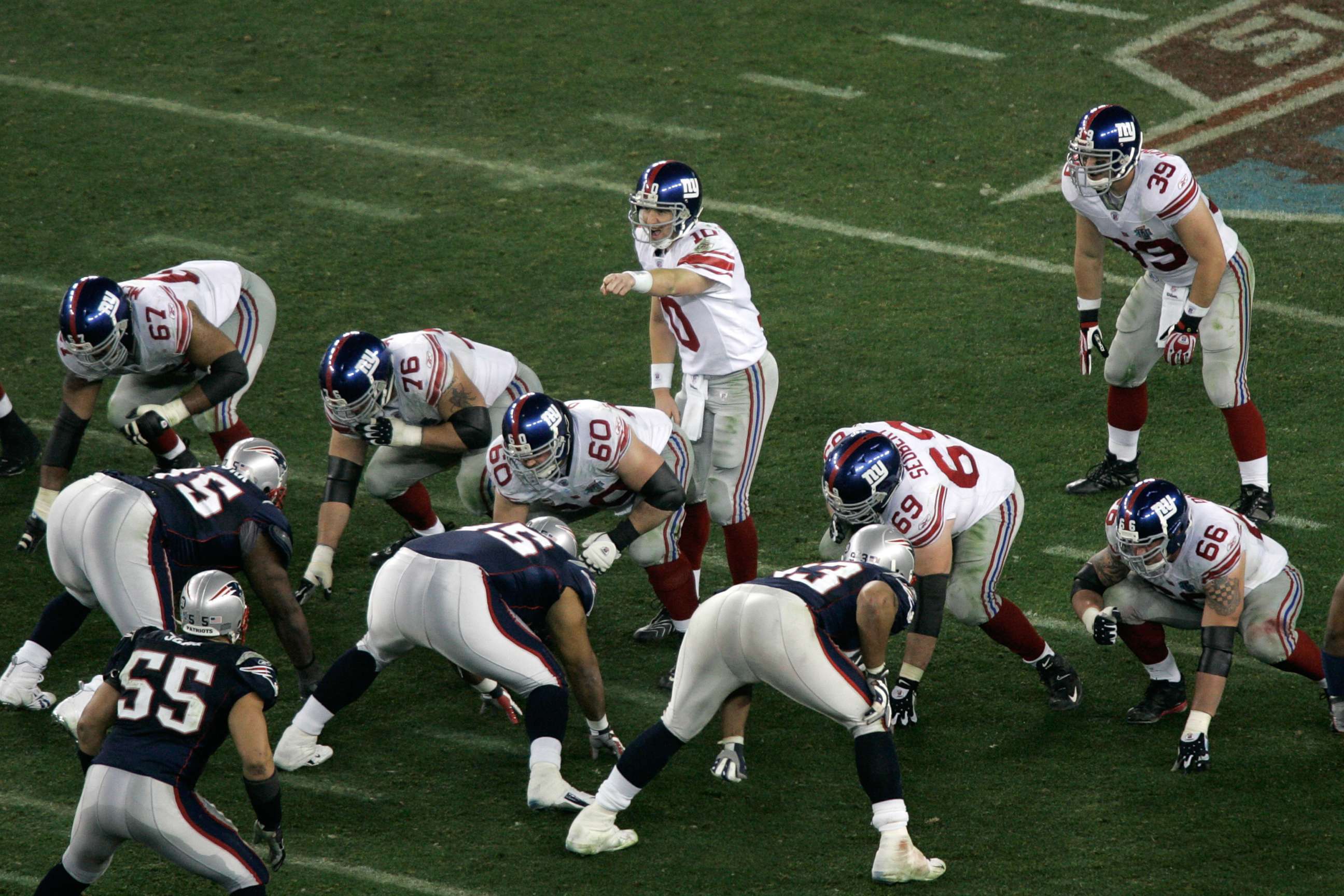 PHOTO: Quarterback Eli Manning #10 of the New York Giants points as he calls out signals prior to the snap at the line of scrimmage against the New England Patriots during Super Bowl XLII at University of Phoenix Stadium, Feb. 3, 2008, in Glendale, Ariz. 