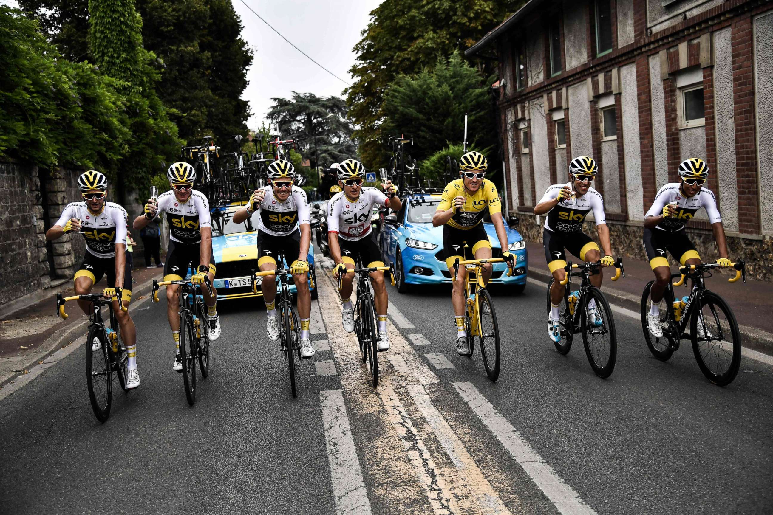 PHOTO: Bikers drink champagne during the 21st and last stage of the 105th edition of the Tour de France cycling race between Houilles and Paris Champs-Elysees, July 29, 2018. 