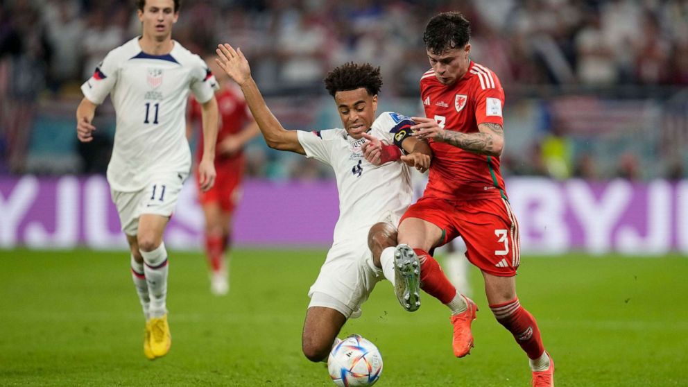 PHOTO: Tyler Adams of the United States, and Wales' Ben Davies vie for the ball during the World Cup, group B soccer match between the United States and Wales, at the Ahmad Bin Ali Stadium in in Doha, Qatar, Nov. 21, 2022.
