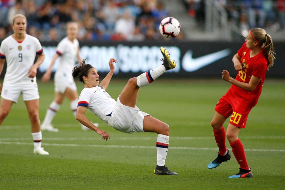 PHOTO: Carli Lloyd #10 of United States Women's National Team kicks the ball away from Julie Biesmans #20 of Belgian Women's National Team during the first half of a game at Banc of California Stadium, April 7, 2019, in Los Angeles.