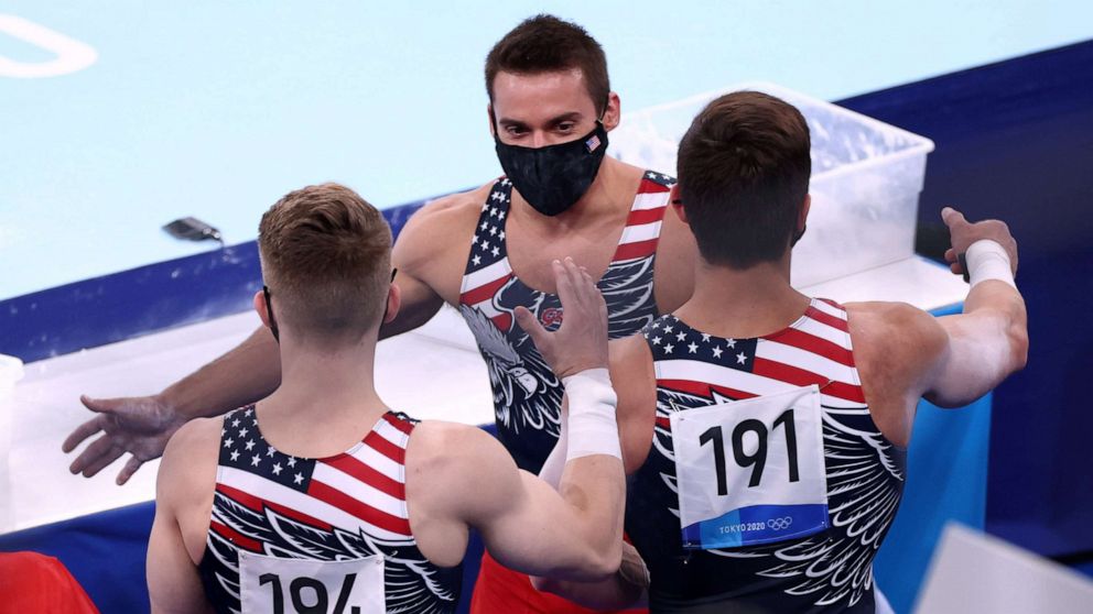 PHOTO: United States' Samuel Mikulak celebrates with Shane Wiskus and Brody Malone of the after competing on the pommel horse, July 26, 2021, at the Tokyo Olympics.