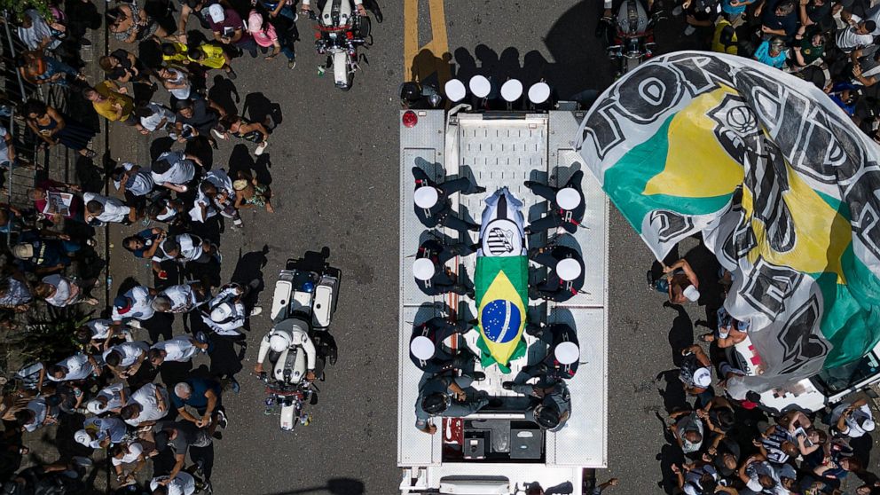 The remains of late Brazilian soccer great Pele are carried into Necropole Ecumenica Memorial Cemetery at the end of his funeral procession in Santos, Brazil, Tuesday, Jan. 3, 2023. (AP Photo/Andre Penner)