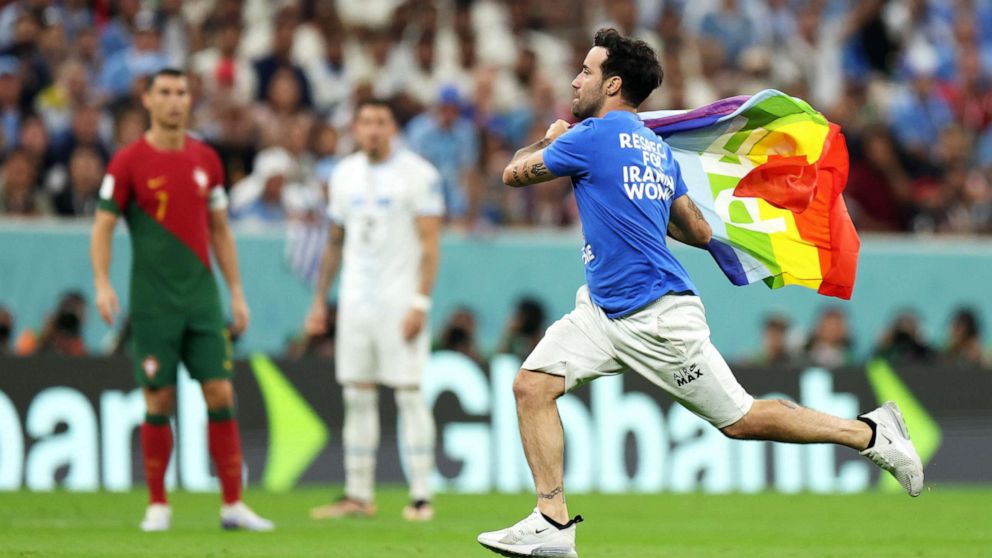 PHOTO: A pitch invader wearing a shirt reading "Respect for Iranian woman" holds a rainbow flag during the FIFA World Cup Group H match between Portugal and Uruguay at Lusail Stadium on Nov. 28, 2022, in Lusail City, Qatar.