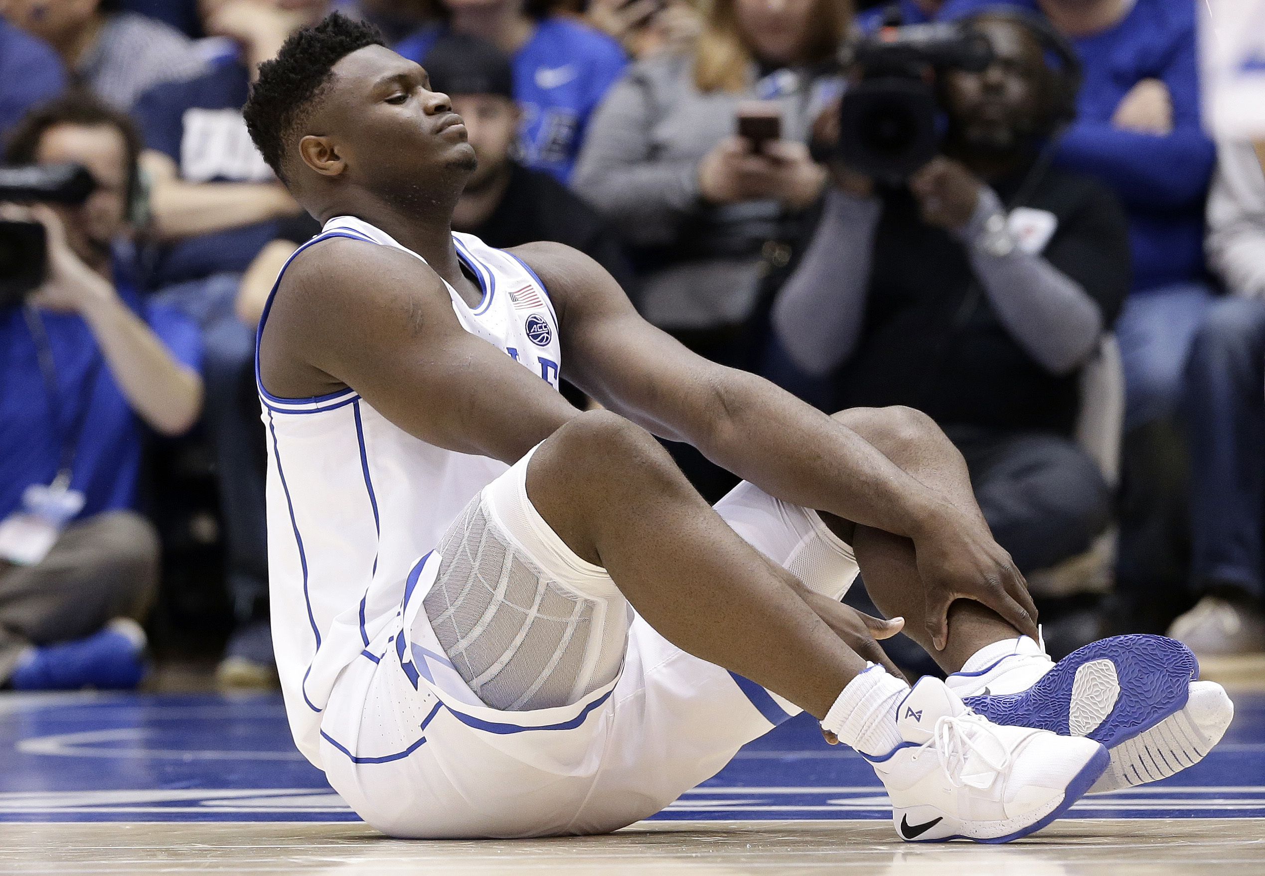PHOTO: Duke's Zion Williamson sits on the floor following a injury during the first half of an NCAA college basketball game against North Carolina in Durham, N.C., Wednesday, Feb. 20, 2019.