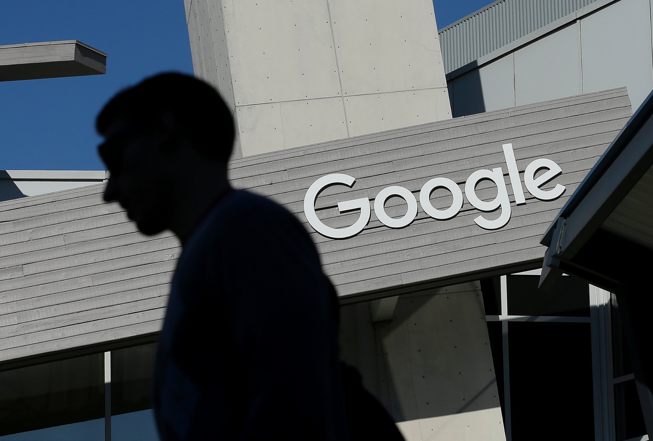 A man walks past a building on the Google campus in Mountain View, Calif.