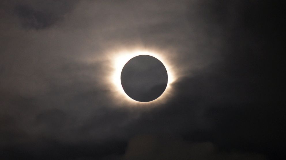 PHOTO: A total solar eclipse is visible through the clouds as seen from Vagar on the Faeroe Islands, March 20, 2015.  