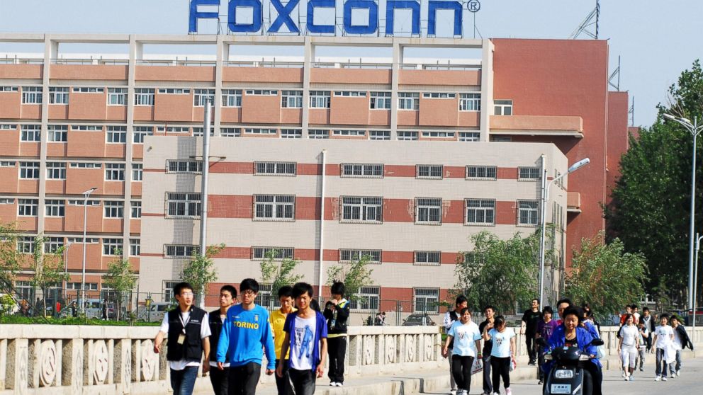 Chinese Foxconn employees walk across a bridge in front of the Foxconn Yantai plant in Yantai City, China, June 5, 2010.