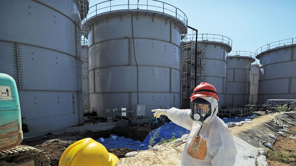 Japanese Trade Minister Toshimitsu Motegi, right, inspects storage tanks at the Fukushima Dai-ichi nuclear plant in Fukushima prefecture, northern Japan, Aug. 26, 2013. 
