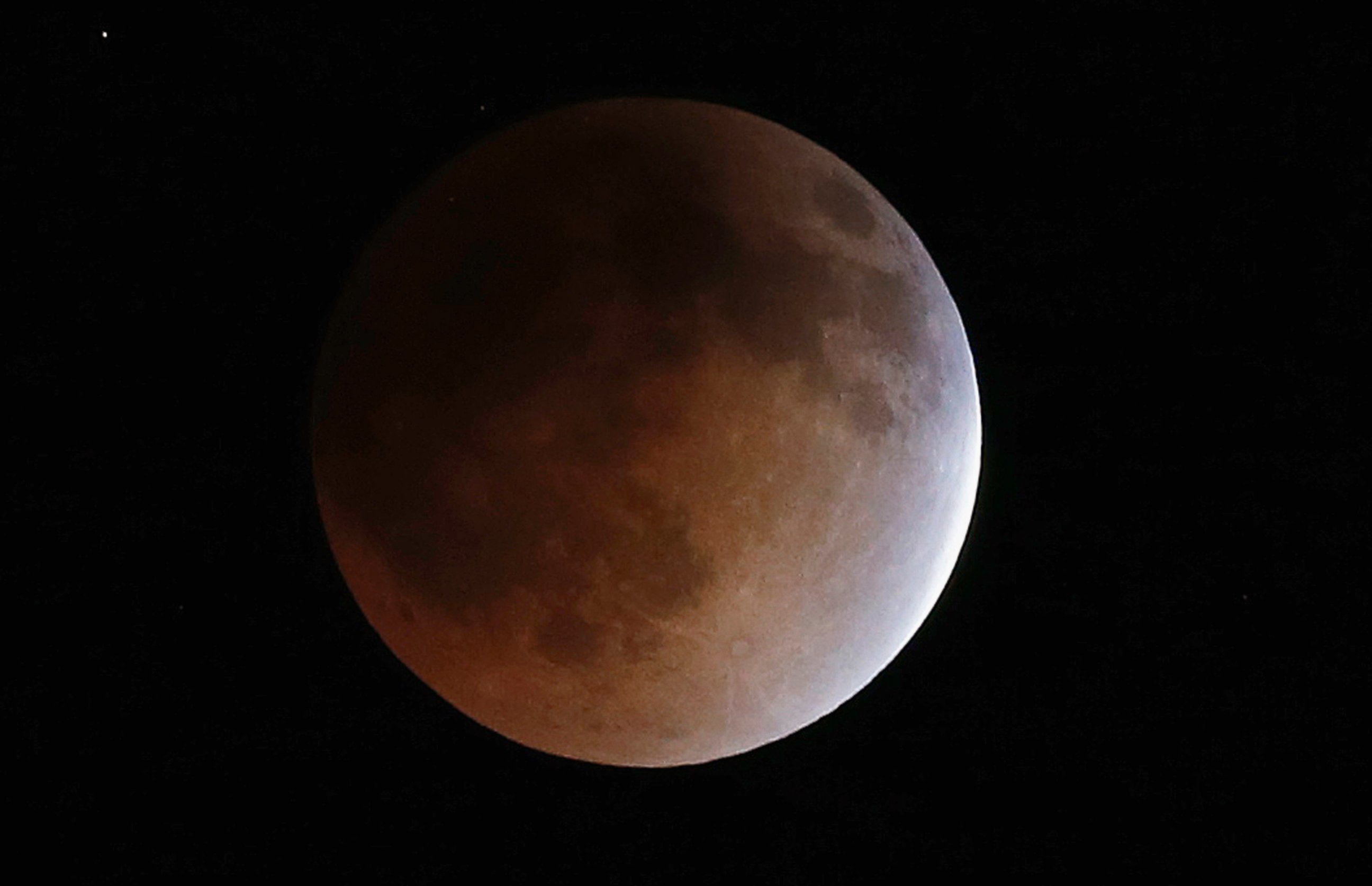 PHOTO: The moon turns an orange hue during a total lunar eclipse in the sky above Phoenix