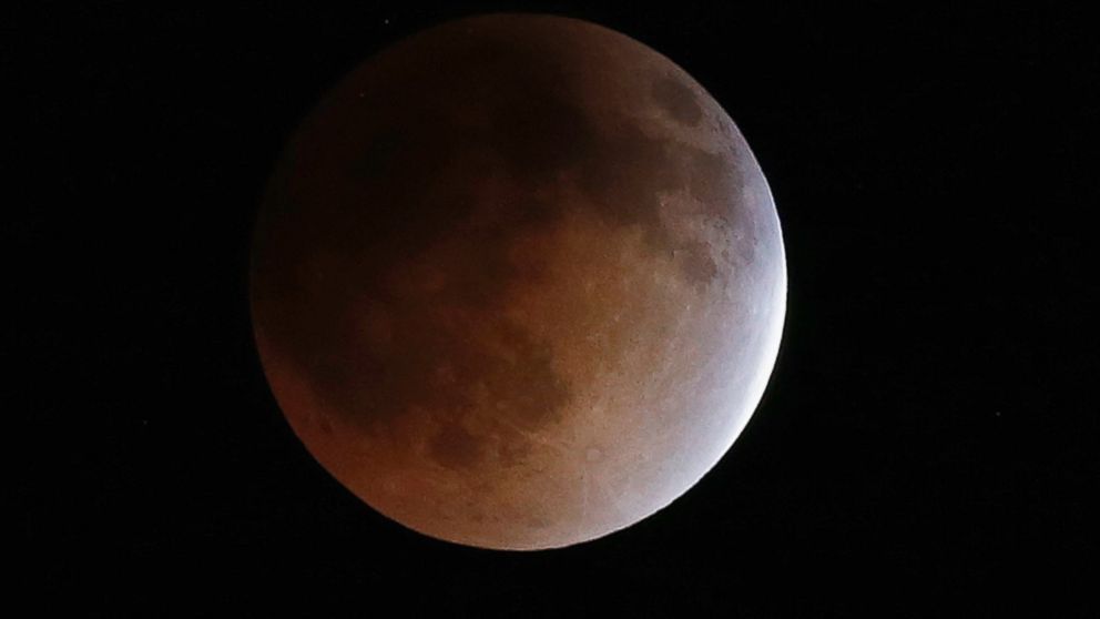 The moon turns an orange hue during a total lunar eclipse in the sky above Phoenix, April 15, 2014.