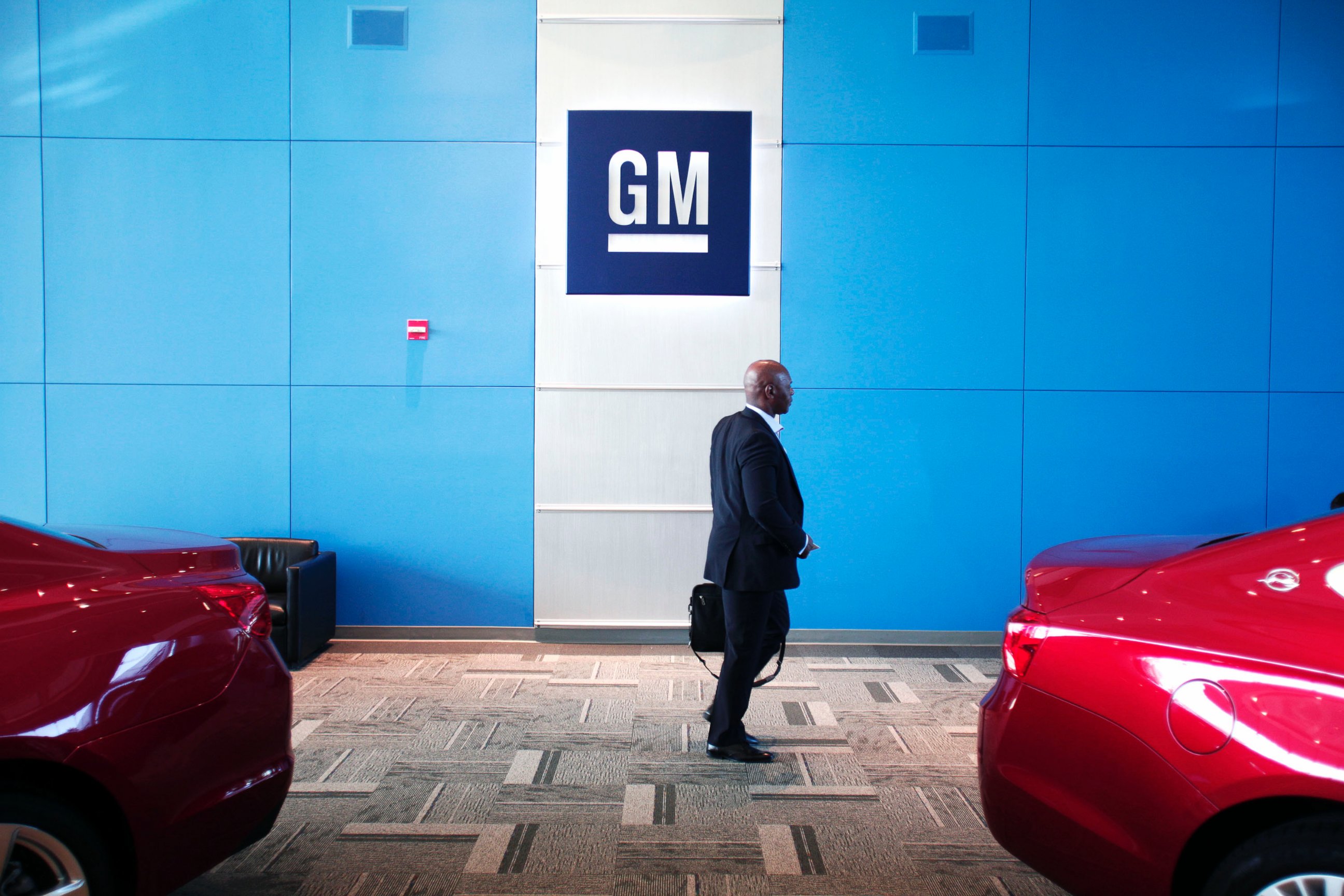 PHOTO: A person walks past the GM logo at the General Motors Technical Center on June 5, 2014 in Warren, Mich. 