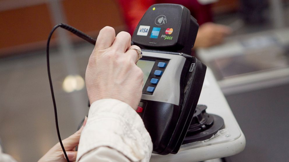 A customer signs her name on a credit card machine while checking out at a BJ's Wholesale Club Inc. store in Falls Church, Virginia, March 27, 2012.
