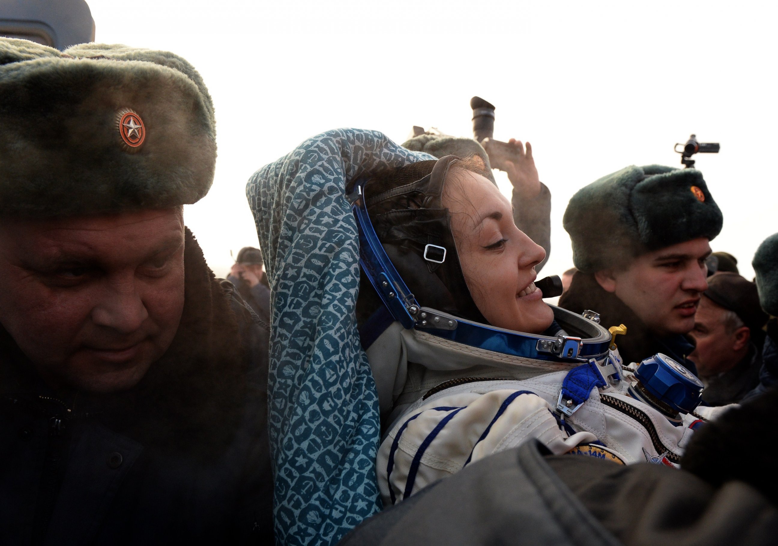 PHOTO: Russia's space agency ground personnel help Russian cosmonaut Yelena Serova after the landing of the Soyuz TMA-10M capsule in the city Karaganda in Kazakhstan, March 12, 2015.