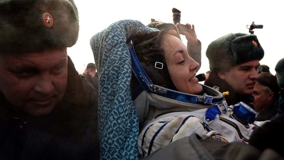 PHOTO: Russia's space agency ground personnel help Russian cosmonaut Yelena Serova after the landing of the Soyuz TMA-10M capsule in the city Karaganda in Kazakhstan, March 12, 2015.