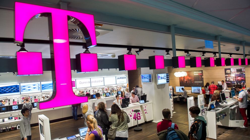 Customers inspect mobile communication devices inside a T-Mobile store, April 24, 2012.