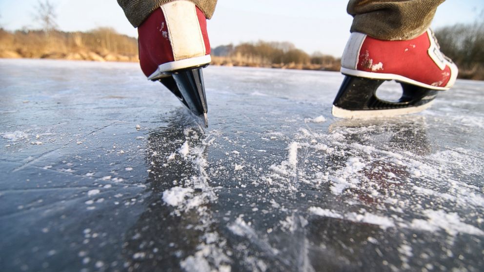 PHOTO: A man maintains balance while skating on ice.