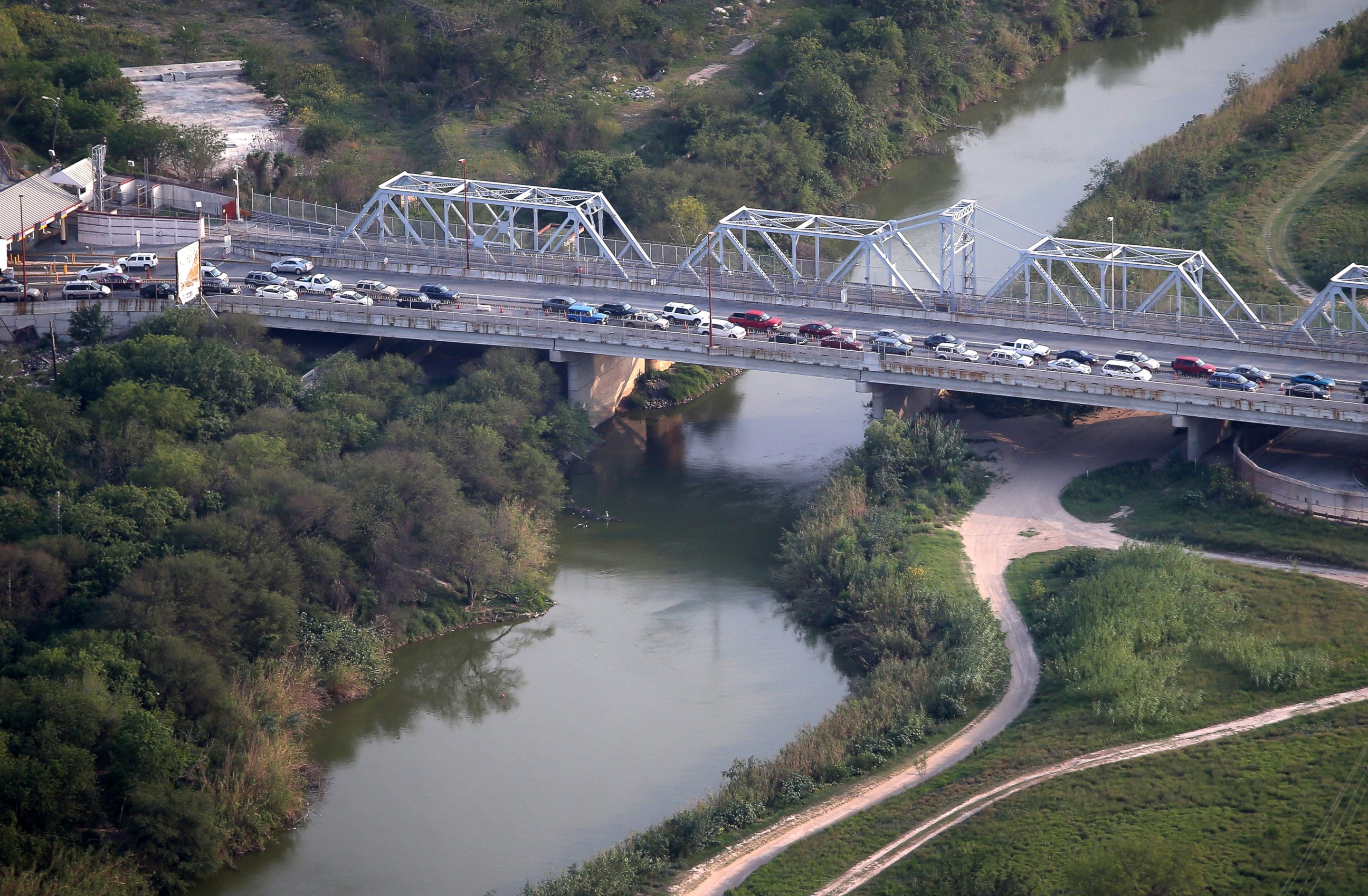 PHOTO: Cars drive from Matomoros, Mexico (L), across the U.S.-Mexico border at the Rio Grande, May 21, 2013, into Brownsville, Texas.