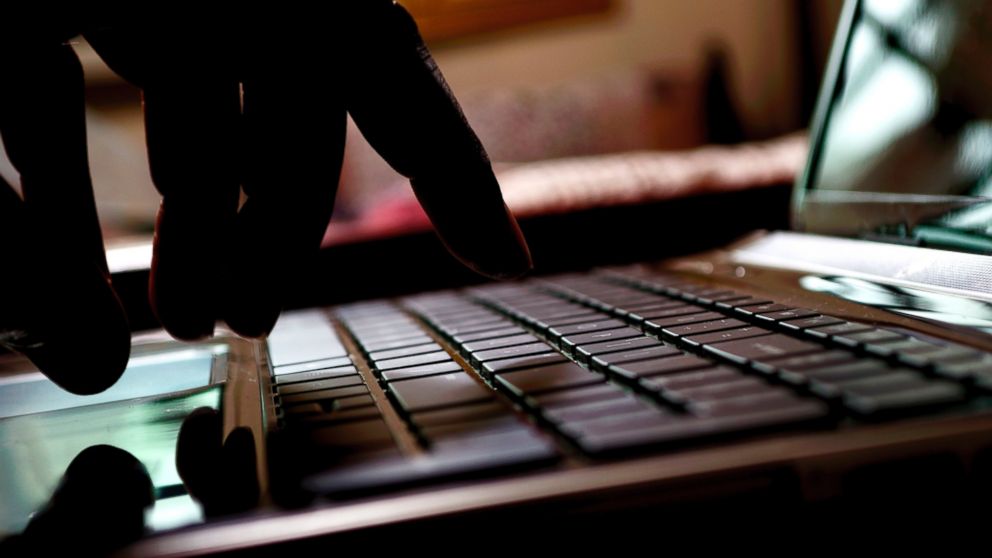 A hacker types on a laptop in this stock image.