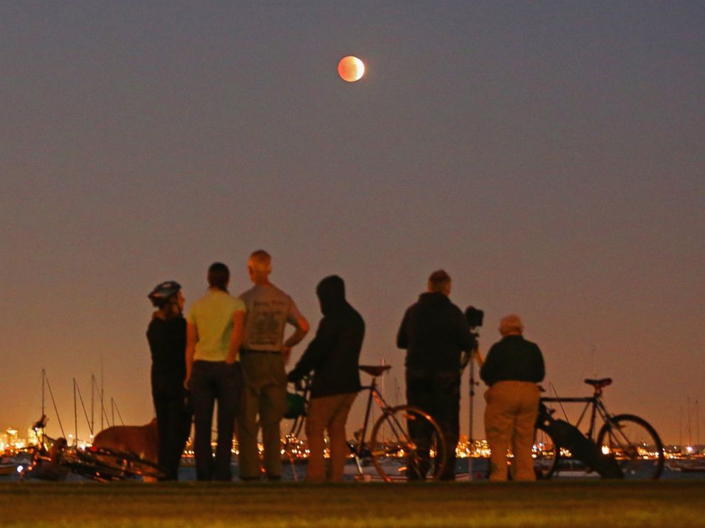 PHOTO: People watch as the Blood Moon rises over the water in Wlliamstown in Melbourne, Australia