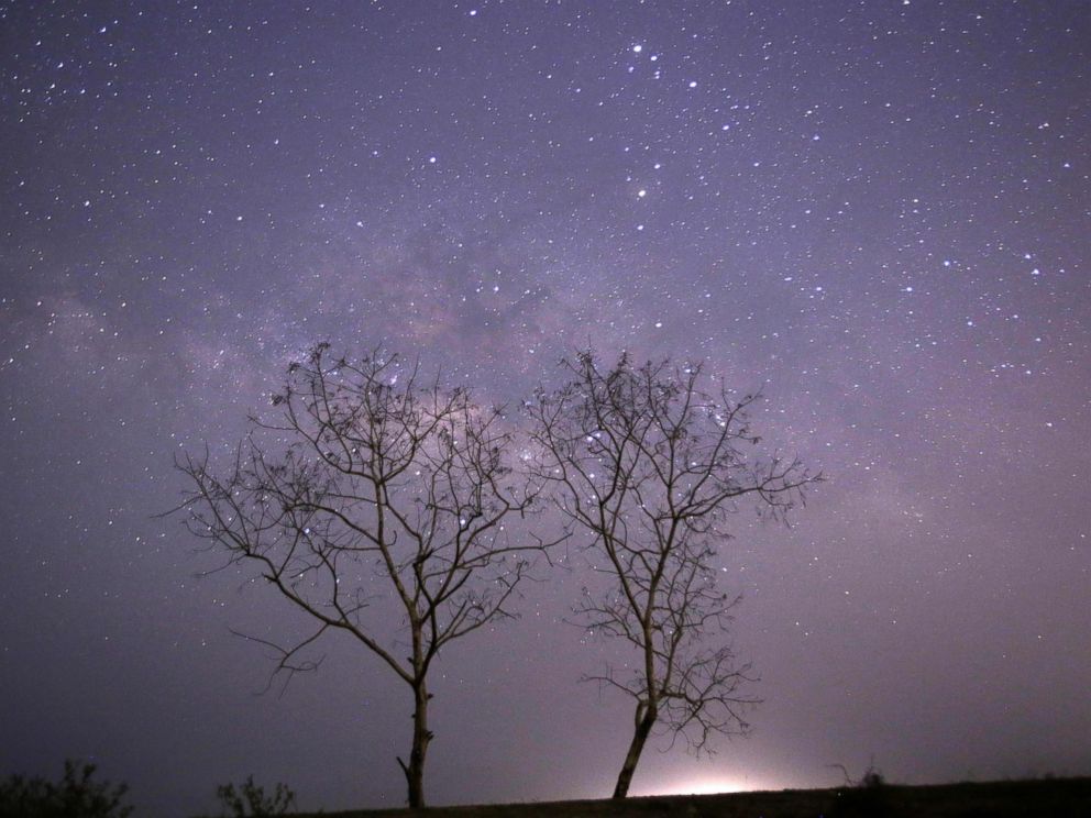 PHOTO: This long-exposure photograph taken on Earth Day shows the Lyrids meteor shower passing near the Milky Way in the clear night sky of Thanlyin, nearly 14 miles away from Yangon on April 23, 2015.