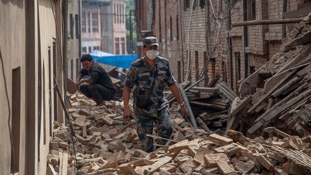 PHOTO: A member of police forces walk down a street covered in debris after buildings collapsed, April 26, 2015, in Bhaktapur, Nepal.