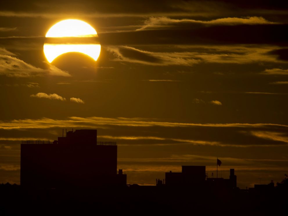 PHOTO: A partial Solar eclipse is seen just after sunrise over the Queens borough of New York across the East River, Nov. 3, 2013.