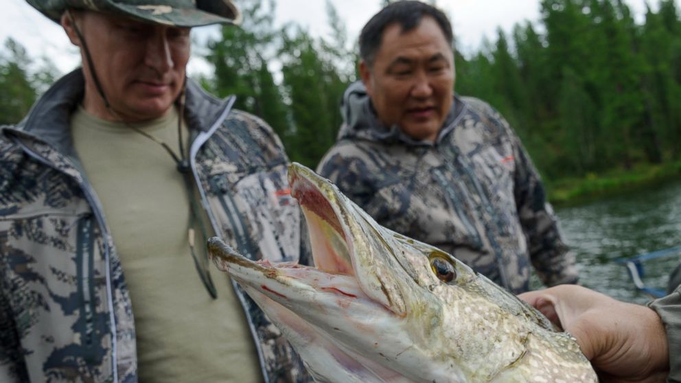 In this file photo, Russian President Vladimir Putin, left, inspects a pike fish he caught on Jul. 20, 2013 in the Tyva region of Russia.