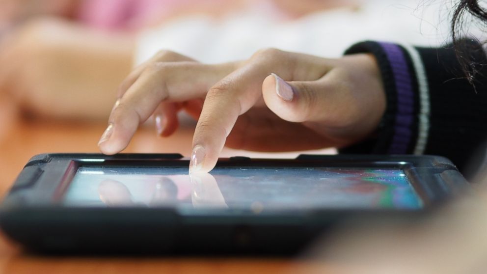 A person using a tablet is pictured in this stock image. 
