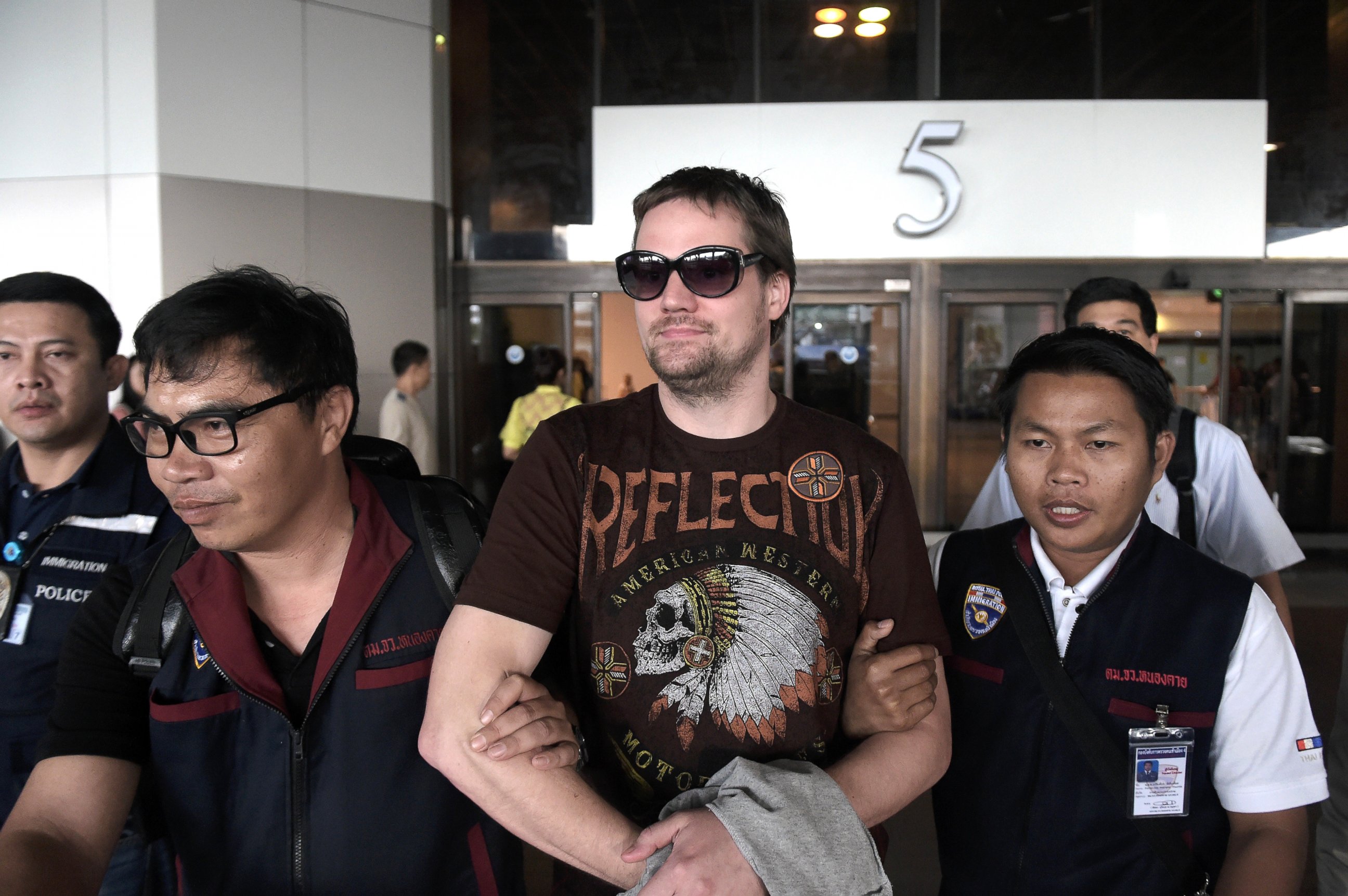 PHOTO: Swedish co-founder of the Pirate Bay website Fredrik Neij, center, is taken by Thai immigration police officers at Don Mueang airport, to an immigration detention center in Bangkok, Nov. 5, 2013. 