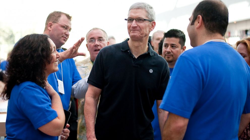 In this handout image provided by Apple, Apple store employees greet CEO Tim Cook at the new Apple Store in this Oct. 27, 2012, file photo in Palo Alto, Calif. 
