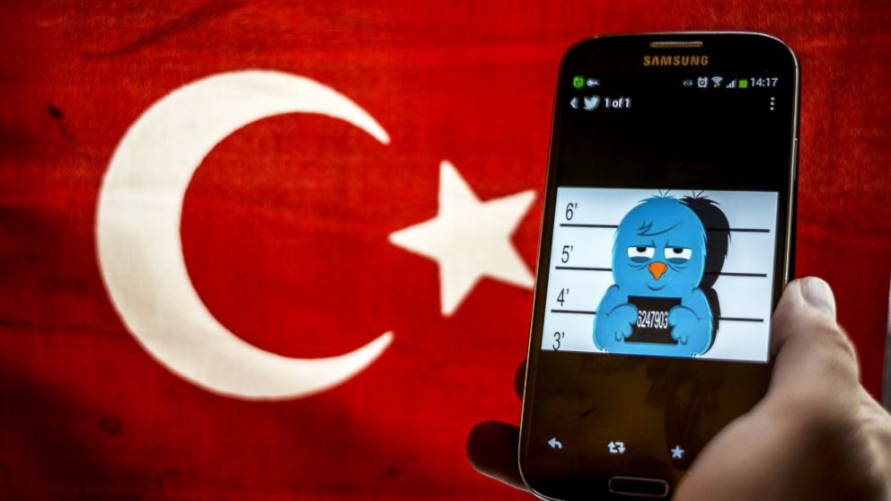 A picture representing a mugshot of the twitter bird is seen on a smart phone with a Turkish flag, March 26, 2014, in Istanbul.