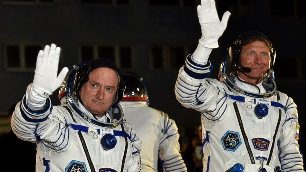 US astronaut Scott Kelly and Russian cosmonaut Gennady Padalka wave after their space suits were tested at the Russian-leased Baikonur cosmodrome, March 27, 2015.