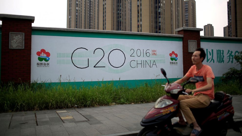A man rides an electronic bike past a billboard for the upcoming G20 summit in Hangzhou, Zhejiang province, China, July 29, 2016.  