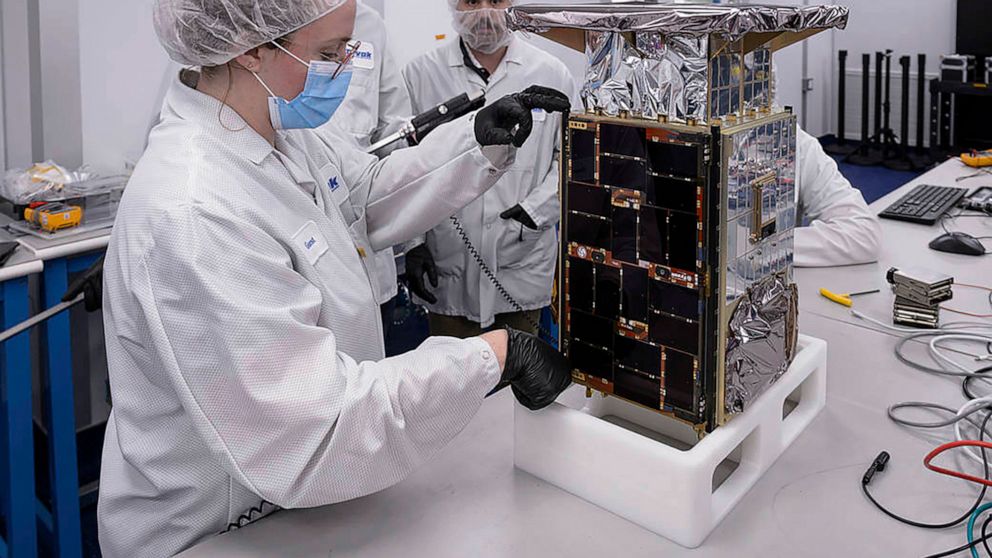 Rebecca Rogers, systems engineer, left, takes dimension measurements of the CAPSTONE spacecraft in April 2022, at Tyvak Nano-Satellite Systems, Inc., in Irvine, Calif. NASA said Tuesday, July 5, that it has lost contact with a $32.7 million spacecraf