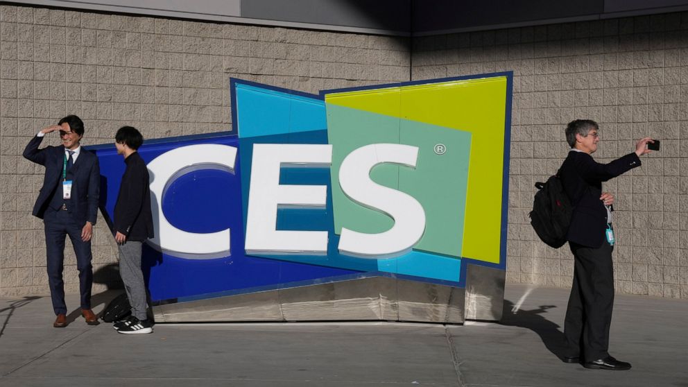FILE - People take pictures in front of a sign during the CES tech show on Jan. 6, 2022, in Las Vegas. CES is returning to Las Vegas in January 2023 with the hope that it inches closer to how it looked before the pandemic. (AP Photo/Joe Buglewicz, File)