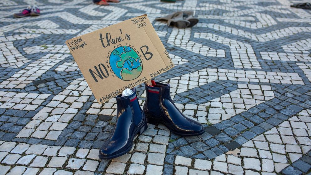 Pairs of shoes with messages about environment protection are placed by activists evenly spaced over a square in Lisbon during a global climate protest, Friday, Sept. 25, 2020. (AP Photo/Armando Franca)