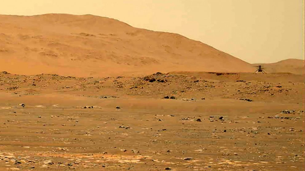 FILE - In this April 30, 2021, file image taken by the Mars Perseverance rover and made available by NASA, the Mars Ingenuity helicopter, right, flies over the surface of the planet. Japanese space agency scientists said Thursday, Aug. 19, 2021 they 