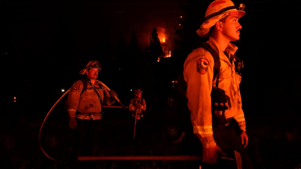FILE - In this Wednesday, Sept. 1, 2021, file photo, firefighters are lit by a backfire set to prevent the Caldor Fire from spreading near South Lake Tahoe, Calif. Thousands of wildfires burn in the U.S. each year, and each one requires firefighters 