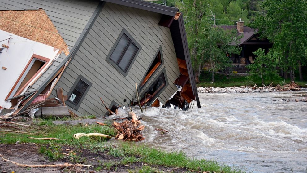 A house that was pulled into Rock Creek in Red Lodge, Mont., by raging floodwaters is seen Tuesday, June 14, 2022. Officials said more than 100 houses in the small city were flooded when torrential rains swelled waterways across the Yellowstone regio