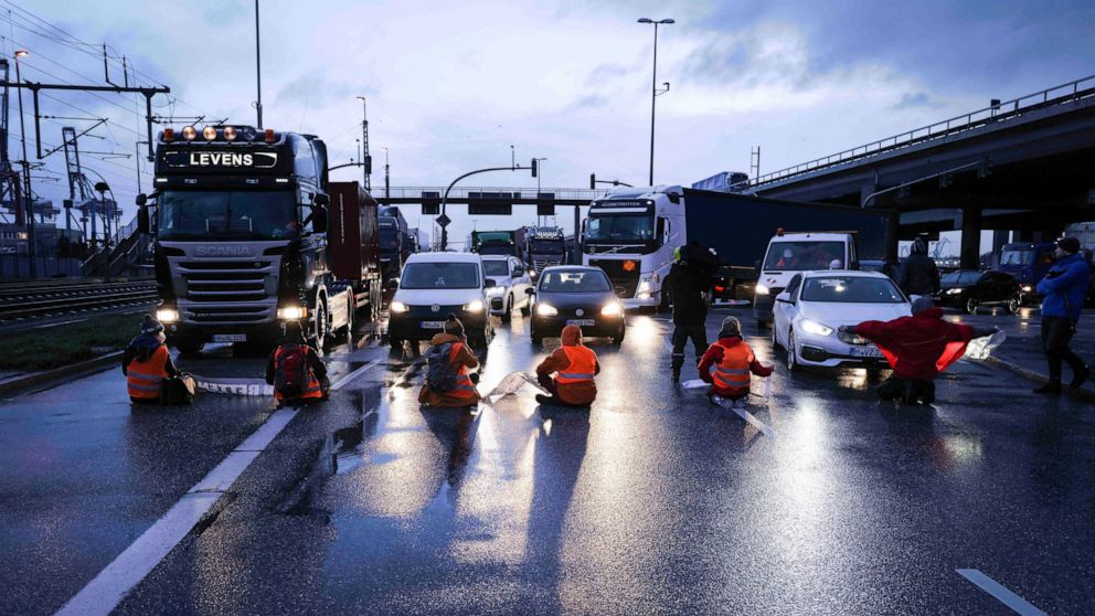 Climate activists of the self named group "Uprising of the last generation" block an intersection at the highway A7 in Hamburg, Germany, Monday, Feb. 21, 2022. (Christian Charisius/dpa via AP)