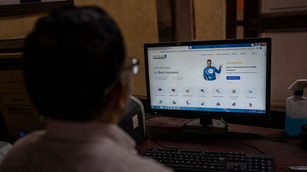 A man looks at the website of policybazaar website at a local insurance company office in Mumbai, India, Wednesday, Aug. 10, 2022. A cybersecurity firm told the major Indian online insurance brokerage last month that critical vulnerabilities in the c